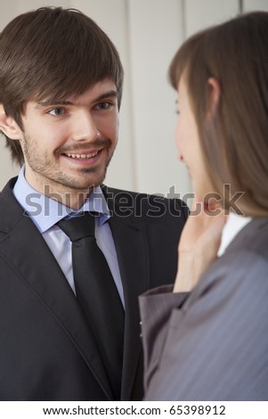 business conversation - man and woman in suits talking together