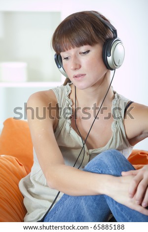 recreation at home - woman with earphones hearing music