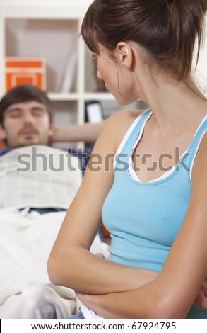 unhappy young woman looking at sleeping man