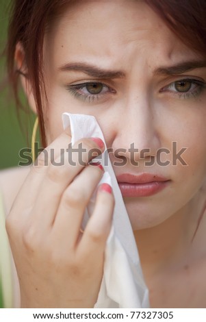 portrait of young crying woman with handkerchief
