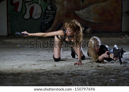 Two sexy female spies in leather outfits shooting from their guns