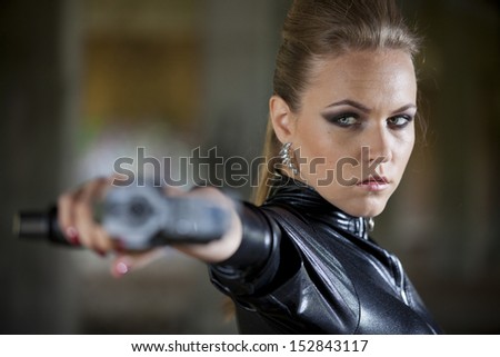 gun woman in fetish leather catsuit shooting