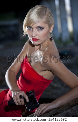 Retro gun woman lying on the wooden box in old fabric ruins