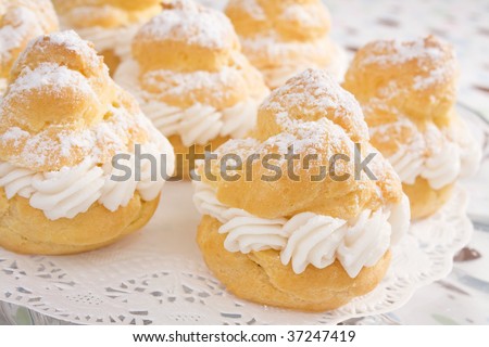 Cream puffs filled with pastry cream and sprinkled with powdered sugar.