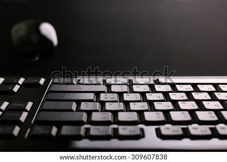 black keyboard close up in focus with black mouse on background