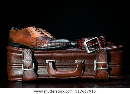 men\'s leather shoes and a suitcase
