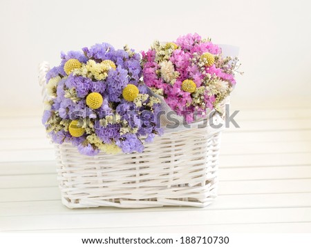 Two small bouquets of dried flowers put into a white basket.