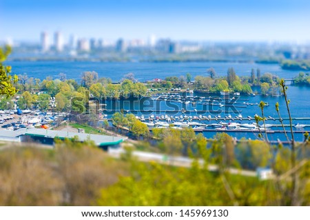 The Kiev's marina and high buildings in the background with a tilt shift effect, seen from the botanic garden