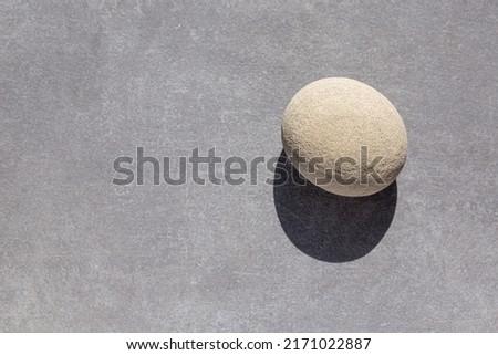 Similar – Image, Stock Photo A nice peeble with a harsh sun shadow on a gray backdrop