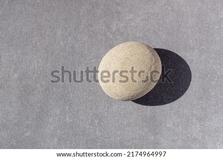 Image, Stock Photo A nice peeble with a harsh sun shadow on a gray backdrop