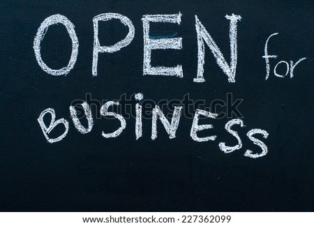 Open for business sign message handwritten with white chalk on blackboard, successful business concept