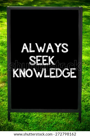 ALWAYS SEEK KNOWLEDGE  message on sidewalk blackboard sign against green grass background. Copy Space available. Concept image