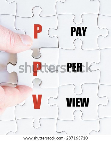 Hand of a business man completing the puzzle with the last missing piece.Concept image of Business Acronym PPV as Pay Per View
