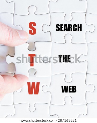 Hand of a business man completing the puzzle with the last missing piece.Concept image of Business Acronym STW as Search The Web