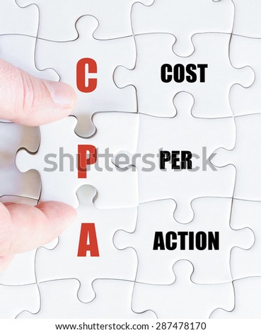 Hand of a business man completing the puzzle with the last missing piece.Concept image of Business Acronym CPA as Cost Per Action