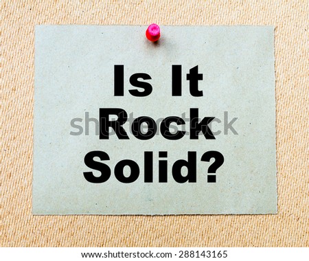 Is It Rock Solid? written on paper note pinned with red thumbtack on wooden board. Business conceptual Image