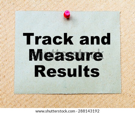 Track And Measure Results written on paper note pinned with red thumbtack on wooden board. Business conceptual Image