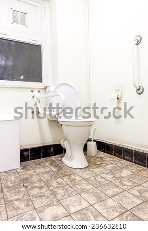 disabled toilet with a broken glass panes