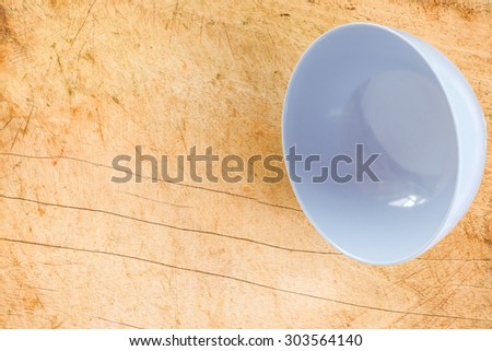 an empty bowl on a wooden board in close up