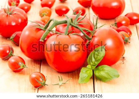tomatoes with basil leave on wooden board