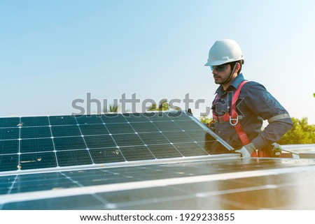A technician installing the solar panels at roof top of home and home office ,concept of economic energy and cost saving ,own small business