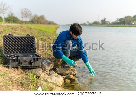 A technician use the Professional Water Testing equipment to measure the water quality at the public canal. Portable multi parameter water quality measurement. Water quality monitoring concept.
