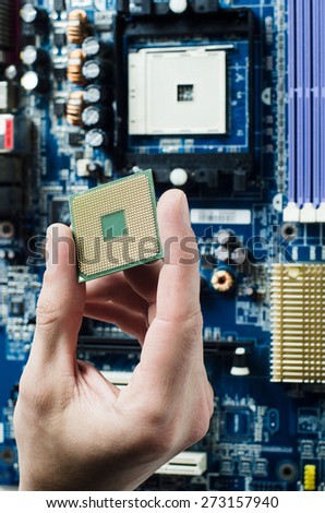 The repair man holding CPU in his hand before installation into the motherboard.