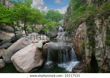 Beautiful cascading waterfall over natural rocks, landscaping element
