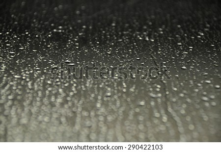 Perspective natural rain drops on glass window with selective focus
