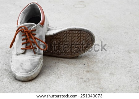 old dirty brown sneaker on gray background