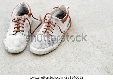 old dirty brown sneaker on gray background
