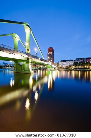Vertical wide angle perspective of the green bridge reflecting in the river