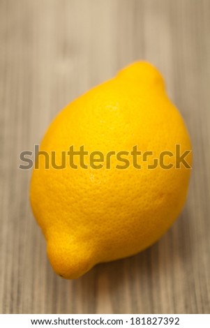Fresh Single yellow lemon on wooden table . Close-up studio photography.selective focus