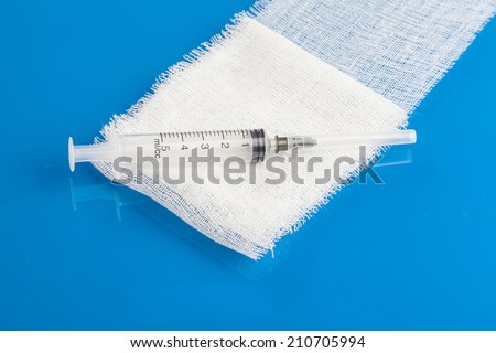 hypodermic needle and accessories, blue background
