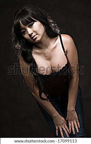 Attractive young Chinese woman leaning forward wearing sexy low cut black tank top