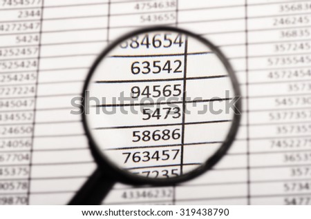 Top view of magnifying glass looking at financial report