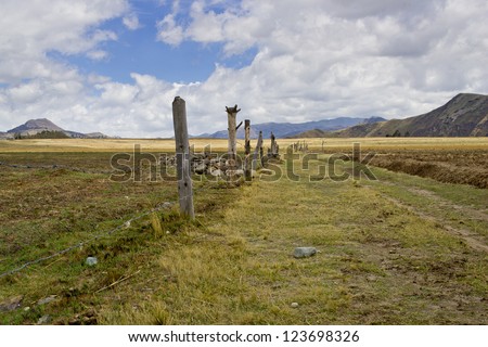 farm road in the high plans (Sierra) of Ecuador, Bluse sky, high clouds and mountains in distant background