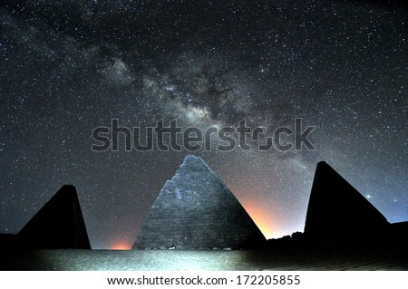 Gebel Barkal Pyramids in Sahara Desert, by night, Sudan, nearby the village of Karima. The central pyramid was illuminated with a torchlight. Behind the Milky Way with Alfa Centaurus on the right