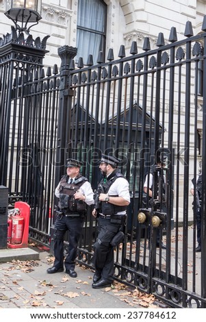LONDON, UK - OCTOBER,10, 2014: Police officers in front of the gate of Downing street, residence of the prime minister, in London United Kingdom