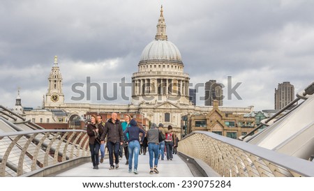 LONDON, ENGLAND, UK - OCTOBER 21, 2014: Tourists walking across the Milenium bridge to St. Paul Cathedral