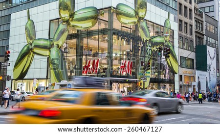 NEW YORK CITY - JULY 29, 2014: Modern H&M shop in 5th street New York City with rushing cabs and people in front.