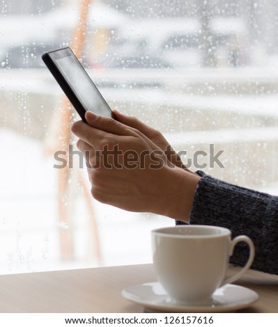 Businessman in a cafe drinking coffee and working on a Tablet PC