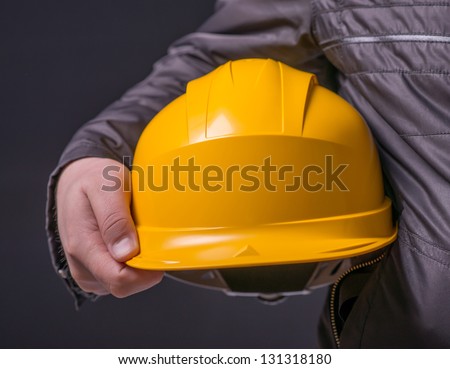 Man with helmet in hand on a black background