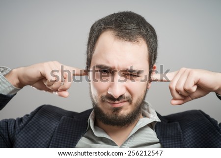 furious young men holding his head in hands and screaming