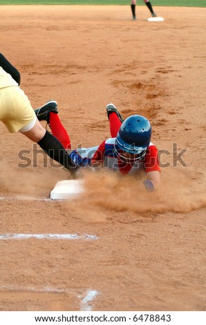 Softball player diving to first base