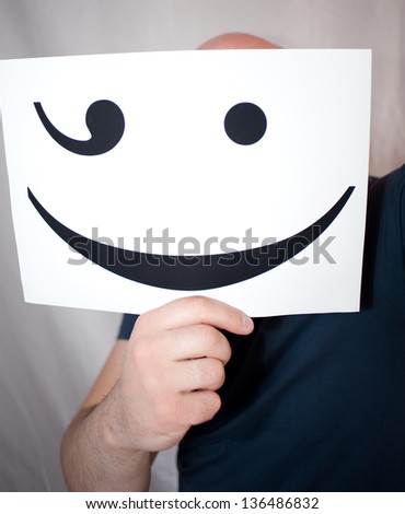 Man holds a smile, causing positive emotions