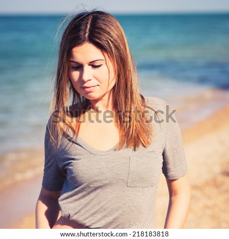 young pretty girl in sexy shorts posing at beach. Fashion summer outdoor portrait of beautiful young woman. Photo with instagram style filters