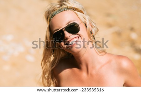 Pretty young hippie caucasian girl, enjoys good weather and the hot sun on a beach. hipster style.