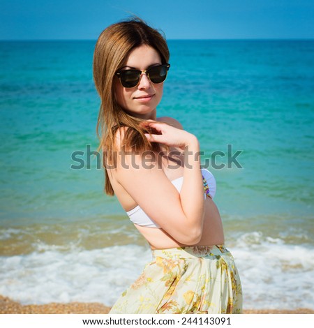 Outdoor fashion warm colors portrait of young sensual happy woman in skirt, bikini and sunglasses. model posing. Photo with instagram style filters
