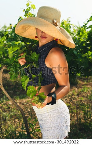Attractive woman with slim tanned body, clean face in sexy shorts and hat posing. Fashion blonde female in vacation enjoys fine warm summer weather